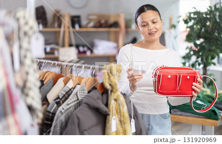 Adult woman choosing handbag in clothing store Adult woman choosing handbag in clothing store 131920969