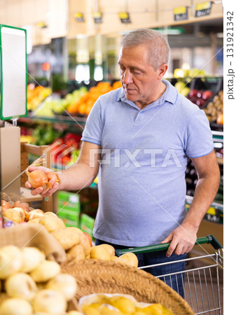 man buy large onion in supermarket man buy large onion in supermarket 131921342