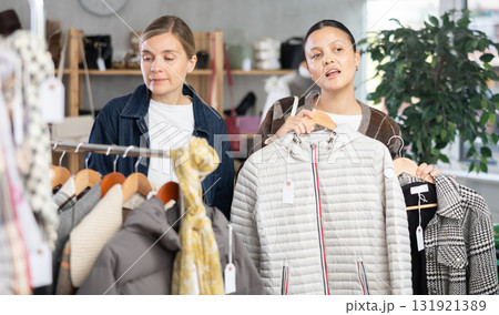 Two women friends browsing goods items and choose elect something autumn outwear 131921389