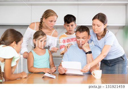 Big family reading upset letter 131921459