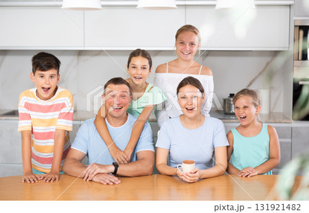 Portrait of happy family - father and mother with four children at table at home 131921482
