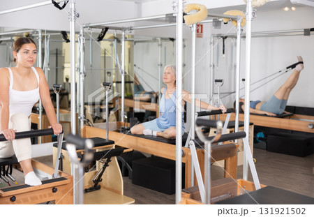 Young girl doing exercises on reformer in pilates studio 131921502