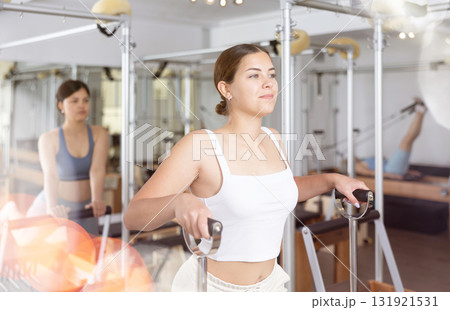 Young girl exercising on wunda chair in pilates studio 131921531