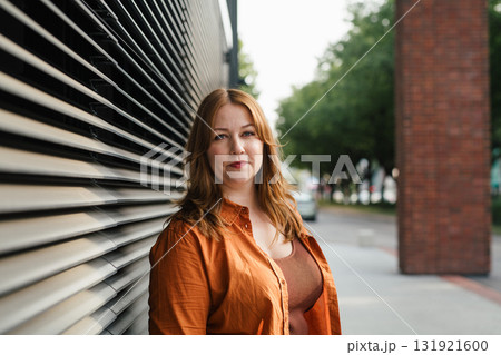 Plus size woman standing outdoors in the city. 131921600