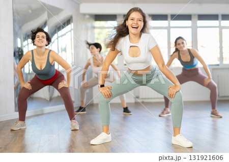 Expressive young woman learning street dancing during group class Expressive young woman learning street dancing during group class 131921606