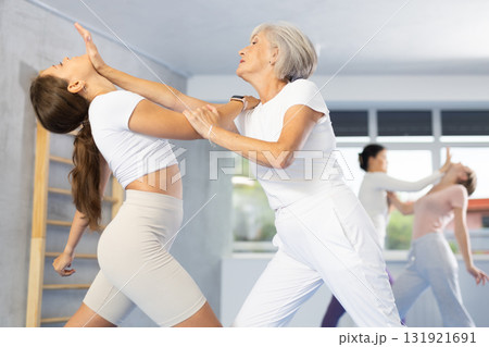 Senior woman using palm to launch blow in chin in sparring during self-defense training Senior woman using palm to launch blow in chin in sparring during self-defense training 131921691