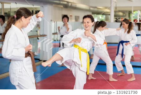 Women practice karate techniques in pairs Women practice karate techniques in pairs 131921730