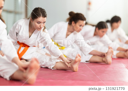 Group of female karatekas doing stretching 131921770