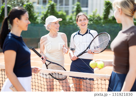 Group of women chatting on tennis court 131921830