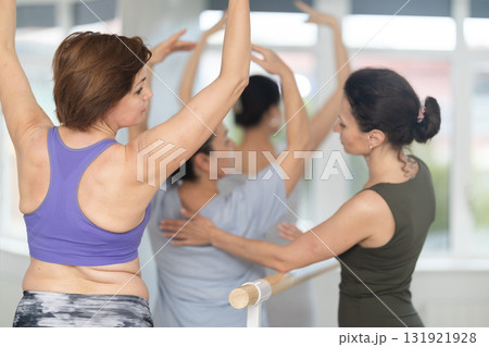 Adult woman teacher correcting beginning dancers 131921928