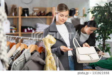 Adult woman choosing handbag in clothing store Adult woman choosing handbag in clothing store 131921938