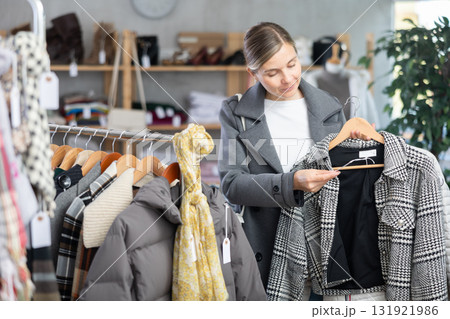 European woman near showcase pick out and buying plaid jacket coat European woman near showcase pick out and buying plaid jacket coat 131921986