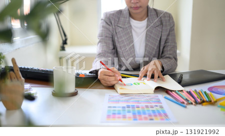 Creative woman working on branding project, hand drawing logo concept at desk 131921992
