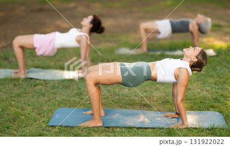 Young woman doing yoga in park 131922022