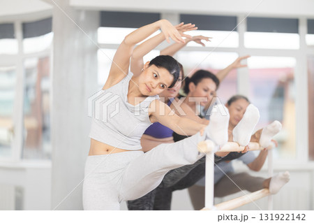 Ballet pose grand batman - women of different ages at choreography lesson 131922142