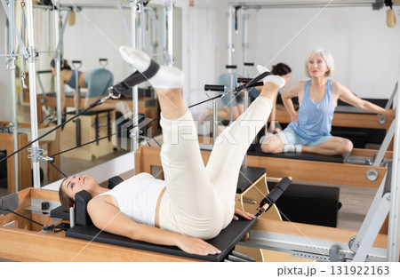 Young girl doing exercises on reformer in pilates studio 131922163