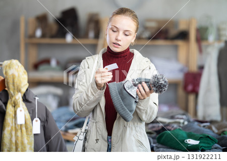 Teenage girl choosing hat in clothing store 131922211