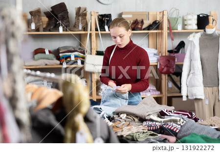 Selective teen girl choosing jean pantaloons in clothing store Selective teen girl choosing jean pantaloons in clothing store 131922272