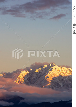 夕日に染まる雪山の山頂_縦 131922279