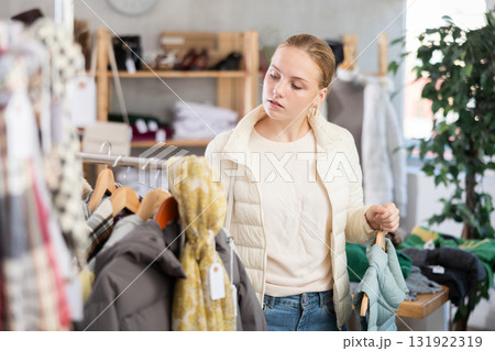 While shopping, teen girl browsing goods items and choose elect something warm outerwear in store While shopping, teen girl browsing goods items and choose elect something warm outerwear in store 131922319