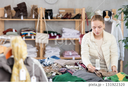 Selective teen girl choosing sweater in clothing store 131922320