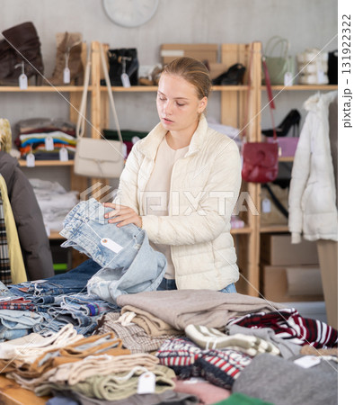 Selective teen girl choosing jean pantaloons in clothing store Selective teen girl choosing jean pantaloons in clothing store 131922322