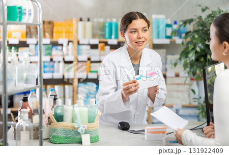 Pharmacist processing order for female customer at pharmacy Pharmacist processing order for female customer at pharmacy 131922409