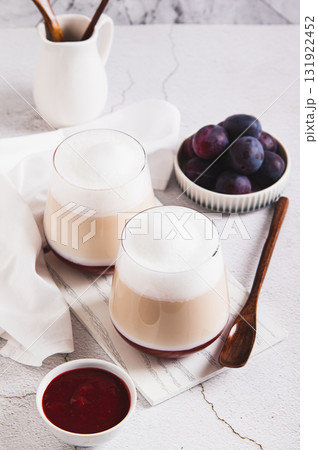 Coffee latte with berry syrup in glasses on the table vertical view 131922452