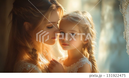 Mother and daughter sharing tender moment in sunlit room, family connection portrait 131922475