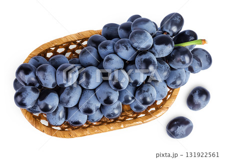 dark blue grape berry bunch in a wicker basket isolated on white background. Top view. Flat lay dark blue grape berry bunch in a wicker basket isolated on white background. Top view. Flat lay 131922561