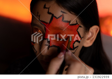 a makeup artist applies makeup to a girl for Halloween party a makeup artist applies makeup to a girl for Halloween party 131922939