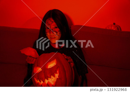 The person is holding a glowing pumpkin in a spooky. The person is holding a glowing pumpkin in a spooky. 131922968