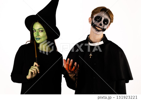 A witch and a person in a skeleton costume are celebrating Halloween 131923221