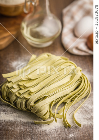 Green tagliatelle pasta on kitchen table. Green tagliatelle pasta on kitchen table. 131923678