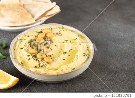 Lupini bean hummus with olive oil, herbs and pita bread on dark background. Vegetarian food. Lupini bean hummus with olive oil, herbs and pita bread on dark background. Vegetarian food. 131923791
