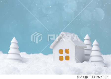 A white wooden toy house with wooden Christmas trees in the snow A white wooden toy house with wooden Christmas trees in the snow 131924002