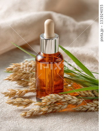 Sea buckthorn oil in amber cosmetic bottle with natural elements and soft fabric background 131924055