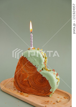 Festive burning candle birthday celebration Delicious fresh croissant topped with Matcha Green Tea flavor Ganache. Creation unique heart shape bakery. Puff pastry holiday love gift present idea Festive burning candle birthday celebration Delicious fresh croissant topped with Matcha Green Tea flavor Ganache. Creation unique heart shape bakery. Puff pastry holiday love gift present idea 131924957