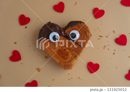 April fool day funny creative eyes on Delicious fresh croissant topped with Dark chocolate flavor Ganache. Creation unique heart shape bakery. Puff pastry holiday love gift present idea Valentine's 131925012