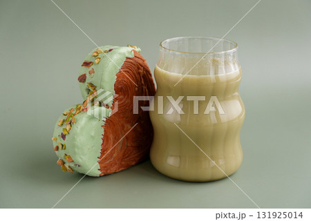 Green tea Matcha latte cappuccino beverage Morning breakfast gift idea Heart shaped pistachio croissant on green background with copy space. Puff pastry trendy sweet dessert bakery. Creamy dough 131925014