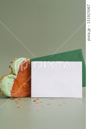 Empty template paper note with envelope greeting card mock up. Heart shaped pistachio croissant on green background with copy space. Puff pastry trendy sweet dessert bakery. Creamy dough experiment  131925067