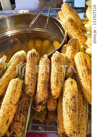 Grilled corn on the cob ready to be served, a tasty street food snack. 131925516