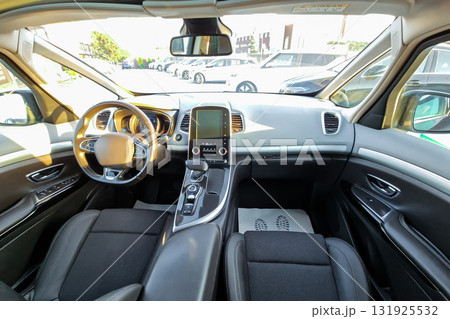 Stylish and modern car interior showcasing sleek design and advanced features in broad daylight at a bustling dealership 131925532
