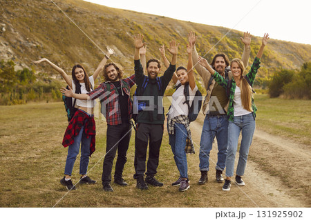 Overjoyed group of tourists looking at camera during walking tour in nature with backpacks. Overjoyed group of tourists looking at camera during walking tour in nature with backpacks. 131925902