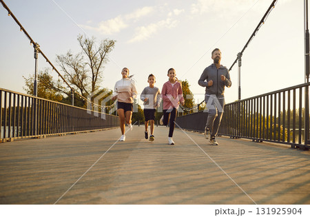 Happy Family With Two Children Jogging In The City Park At Sunset 131925904
