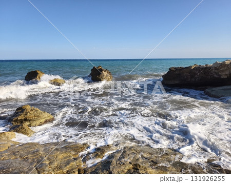 A beautiful and scenic coastal view showcasing vibrant waves crashing against rugged rocks A beautiful and scenic coastal view showcasing vibrant waves crashing against rugged rocks 131926255