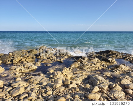 Experience the serene coastal view showcasing beautiful rocks alongside calm waters 131926270