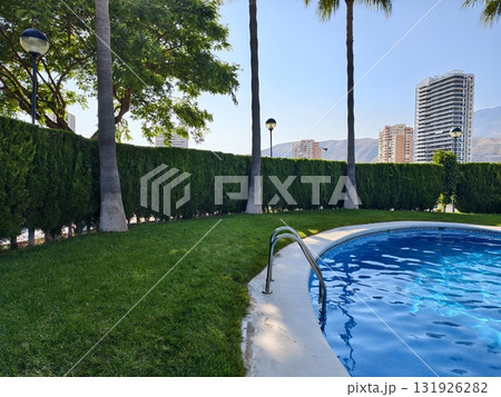 A Serene Swimming Pool Nestled Amidst Luxurious Lush Greenery and Vibrant Cityscape 131926282