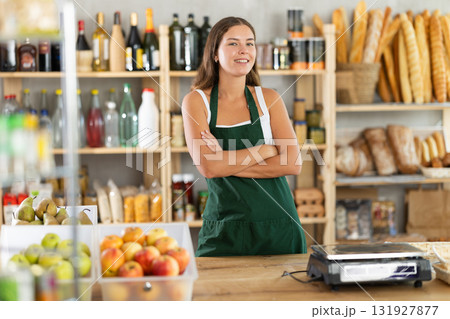Young woman seller at counter in grocery store Young woman seller at counter in grocery store 131927877
