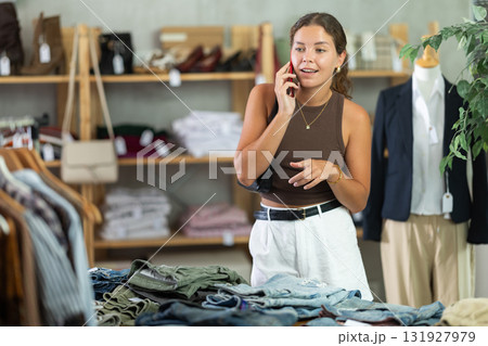 Woman talking on mobile phone in store Woman talking on mobile phone in store 131927979